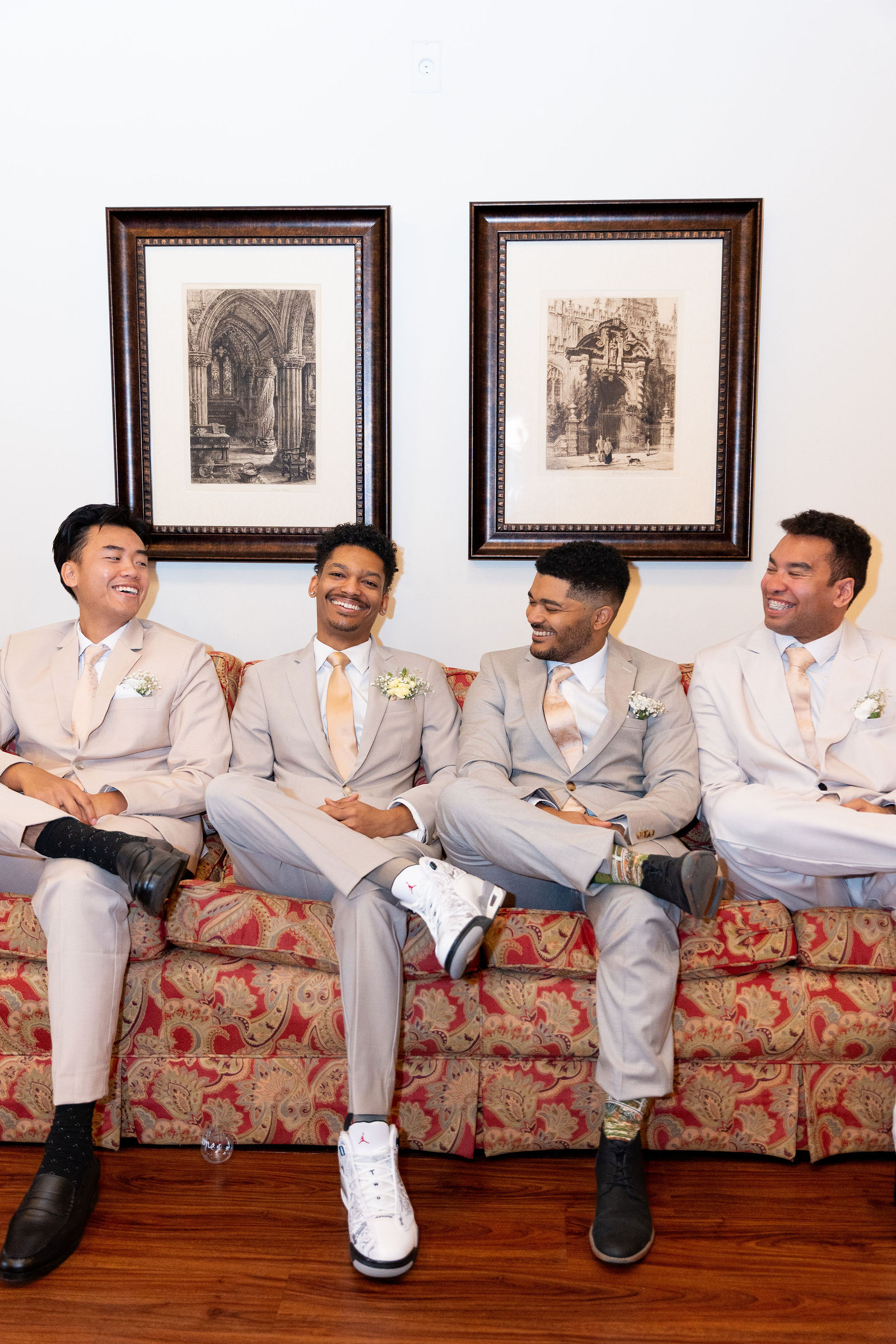 Groomsmen laughing on paisley sofa