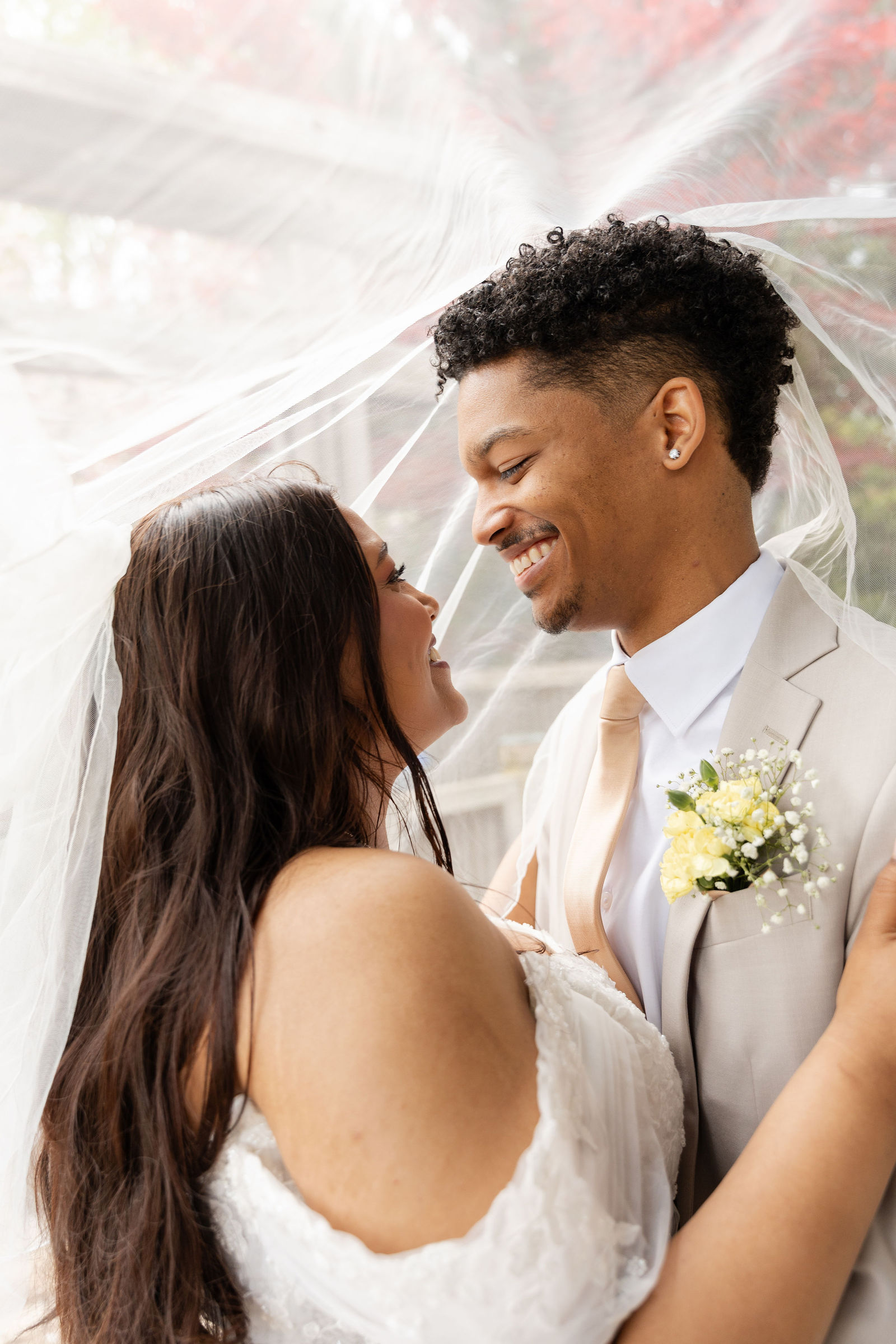Foreheads close beneath her veil