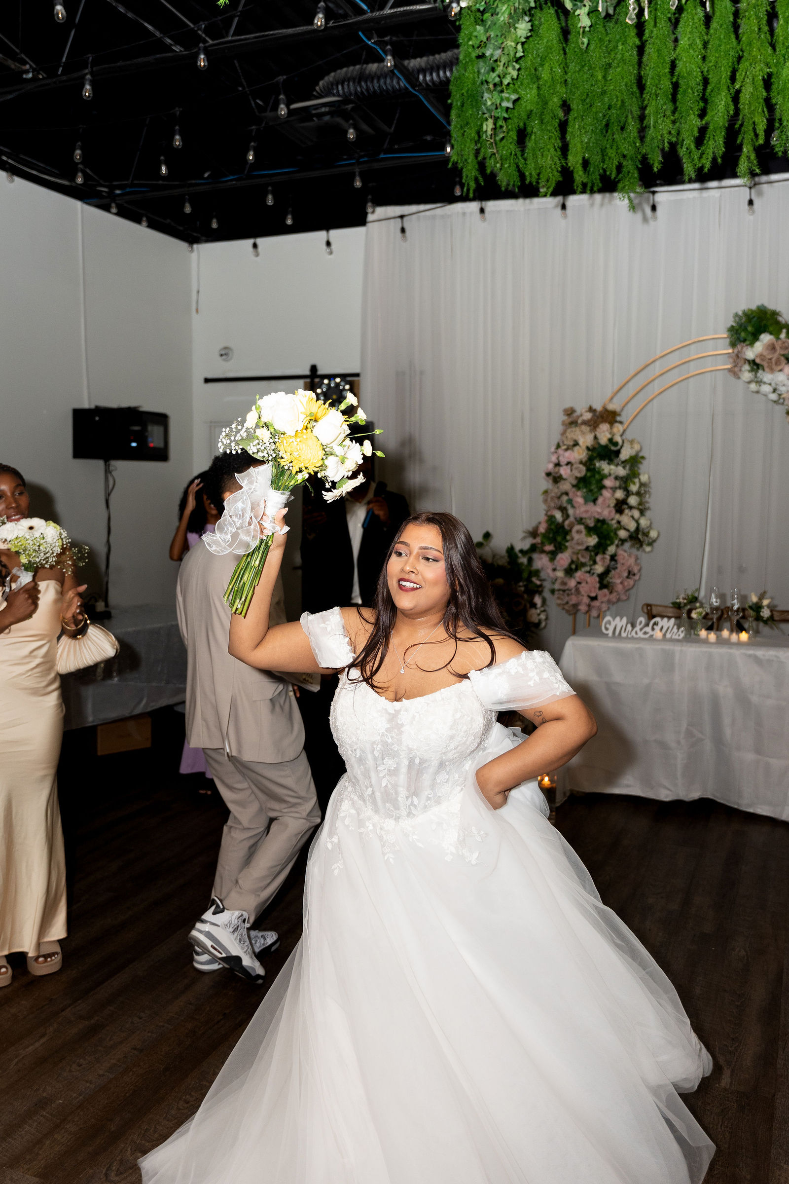 Bride dancing, bouquet lifted