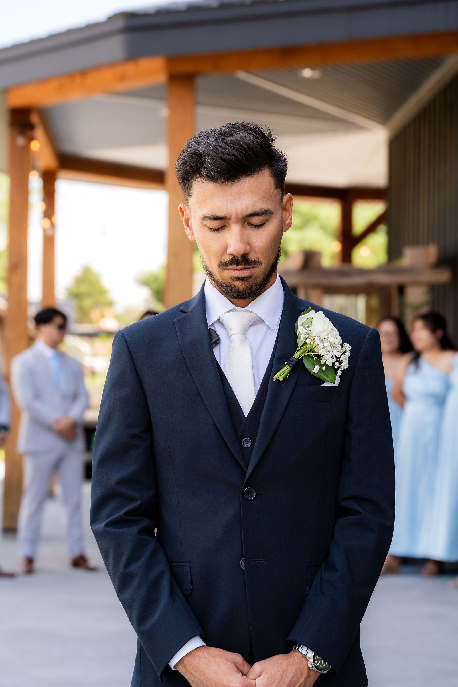 Groom waits, eyes gently closed